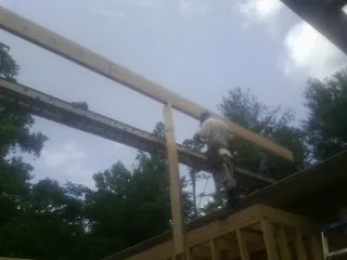 Carpenter setting a ridge beam over a new addition frame — Ice Dam Removal by Roofing Brothers in Sterling